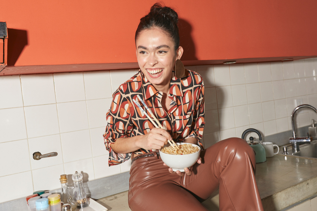 Fashion and Self-Care Woman Eating Noodles in a Kitchen